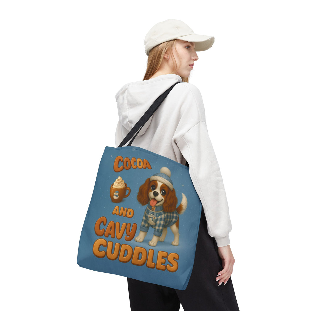 Woman in a cap carrying the Blenheim Cavalier Cocoa and Cavy Cuddles tote over her shoulder, back view